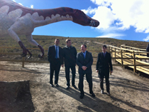 Varios cargos políticos, entre ellos el presidente riojano Pedro Sanz (tercero por la izquierda), bajo la maqueta de Baryonyx, asisten a la inauguración de la nueva adecuación del yacimiento de icnitas de la Era del Peladillo, en Igea (La Rioja).