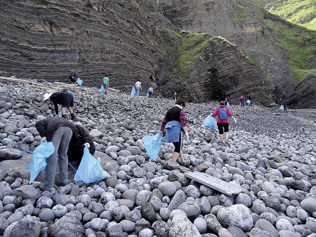 Varios voluntarios recogen basura en una cala del islote de Gaztelugatxe, en Bermeo (Vizcaya). Foto: Fundación Lurgaia.