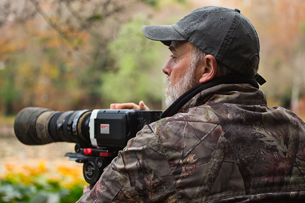 Arturo Menor, cámara en mano durante una jornada de rodaje en el campo.