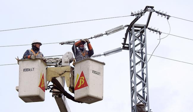 Dos operarios instalan medidas anti-electrocución de aves en un tendido eléctrico (foto: AQUILA a-LIFE).