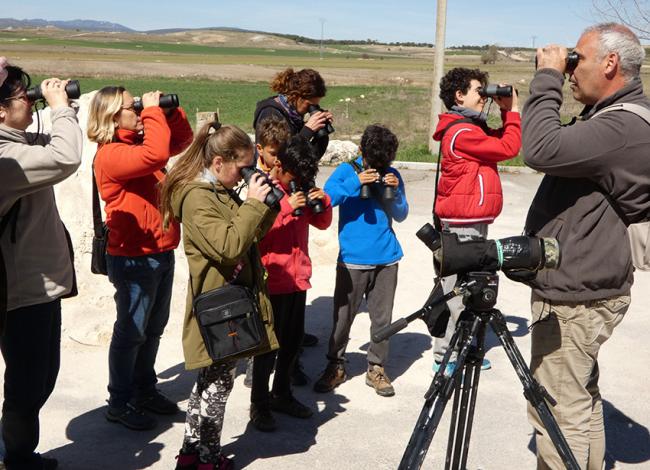 El ornitólogo Manolo Andrés-Moreno guía a varios niños y adultos en un curso de iniciación a las aves de una convocatoria anterior.