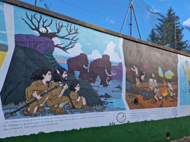 Parte del mural sobre evolución humana elaborado por alumnos de Bellas Artes y que decora un muro de treinta metros en el campus universitario de Teruel (foto: autores).