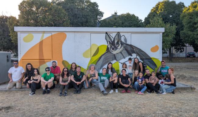 Colaboradores de Pinto en Verde posan junto a un mural realizado bajo la cobertura del proyecto, durante la jornada 
