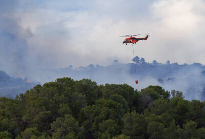 Un helicóptero trabaja en la extinción de un incendio forestal en el Parque Natural de la Font Roja, en la provincia de Alicante, en julio de 2025 (foto: Diego Cano Cabanes / Adobe Stock).